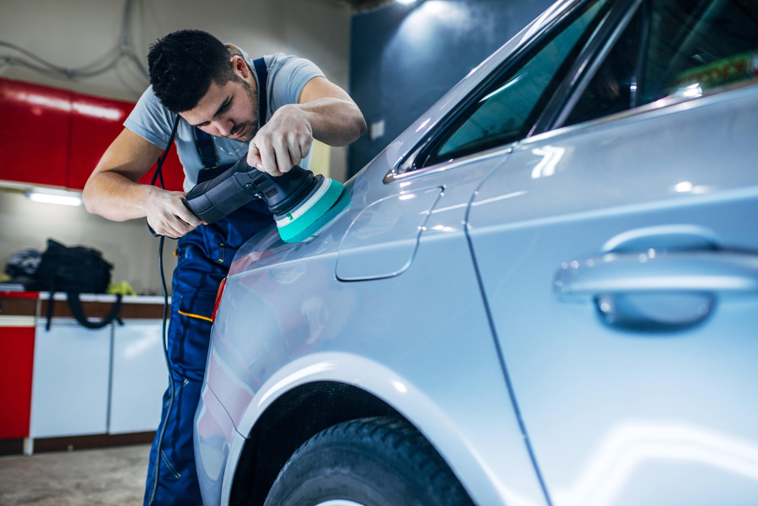 a man buffs paint on a car