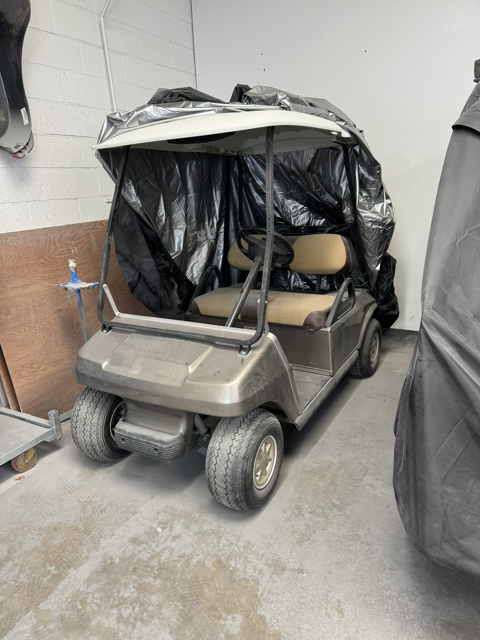 A damaged black Jeep parked in a driveway.