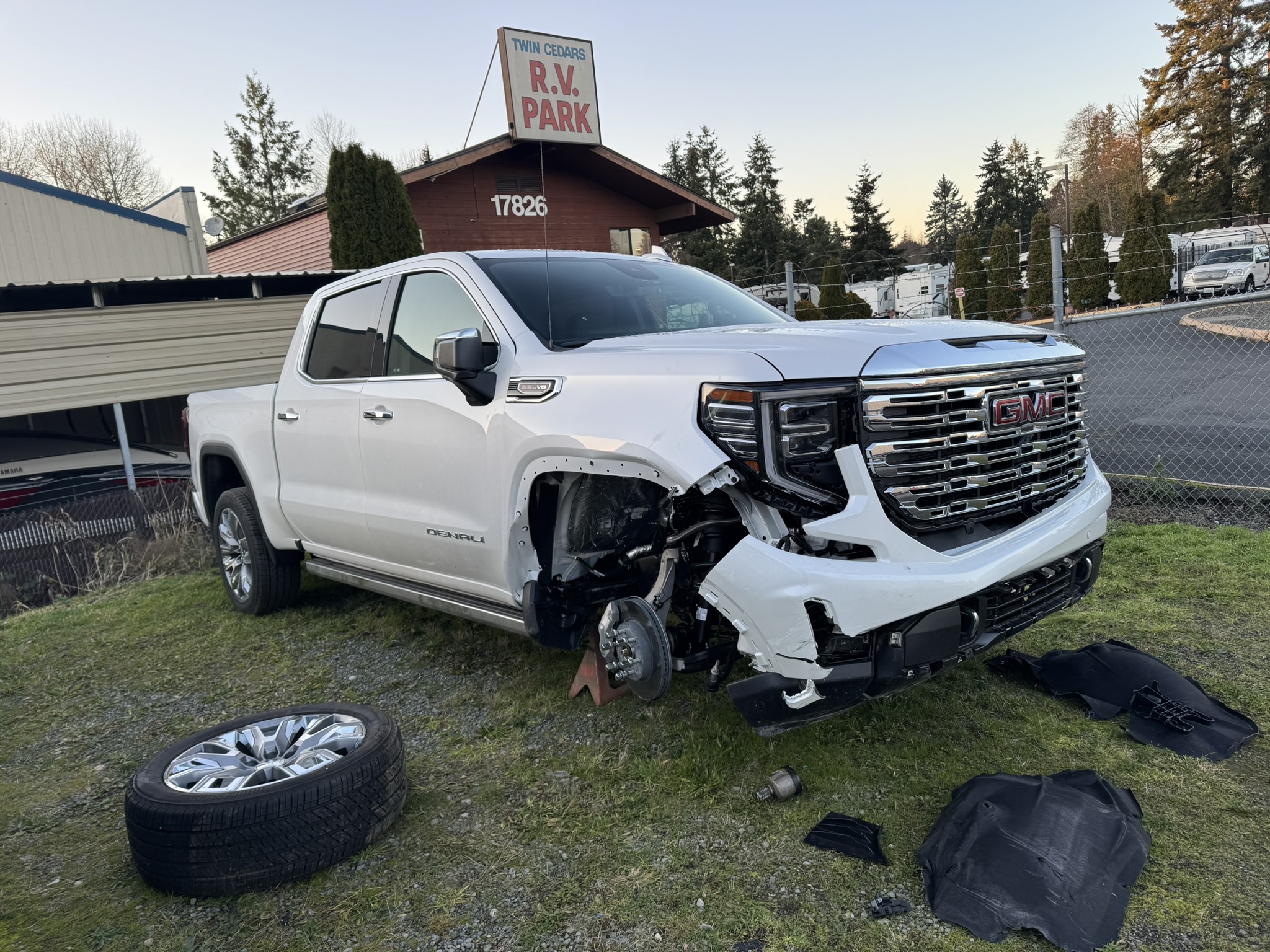 A damaged black Jeep parked in a driveway.